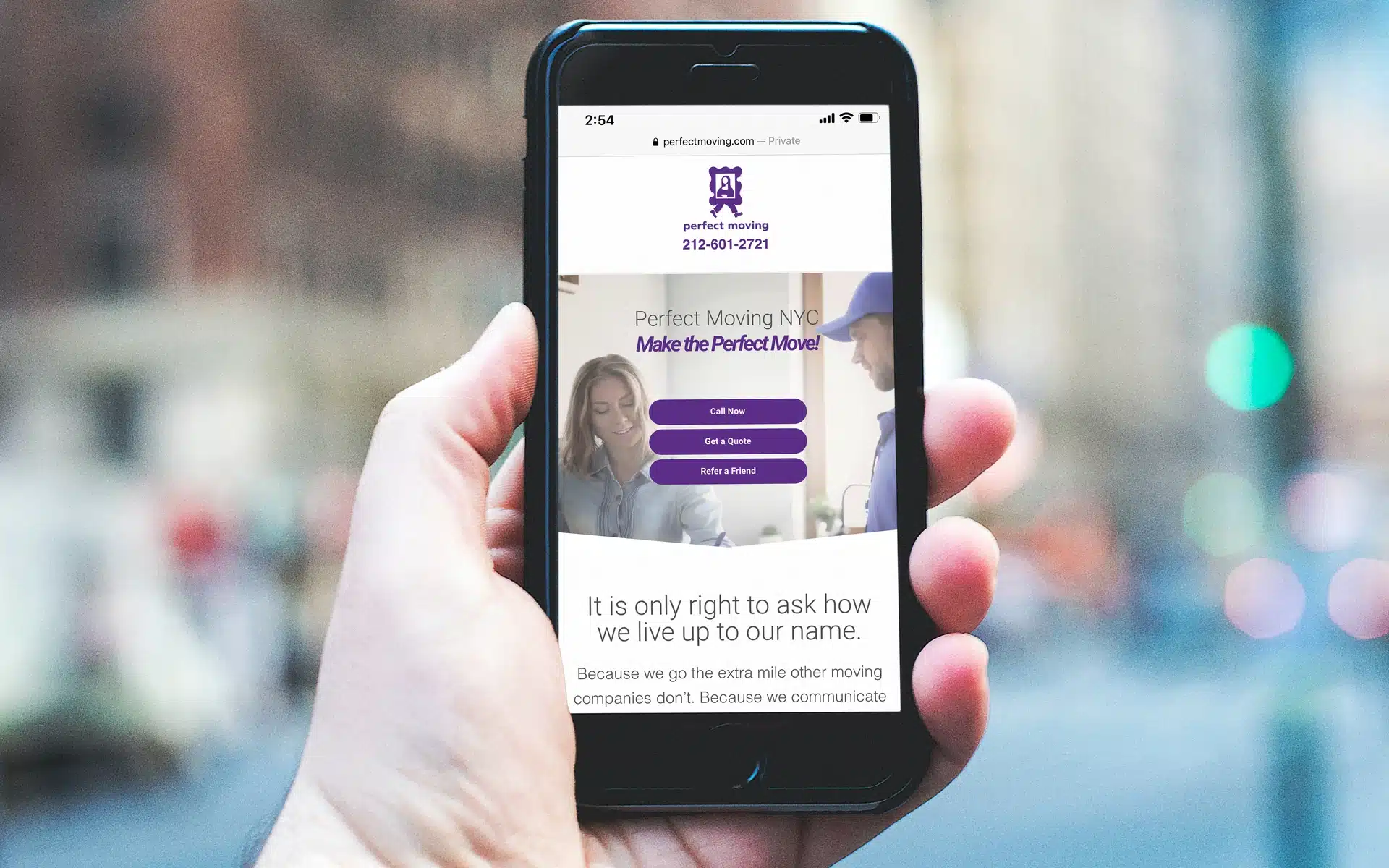 A hand holding a phone open to the Perfect Moving website, with buttons to call or get a quote